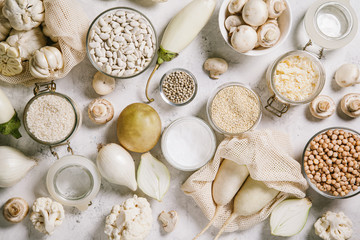 White vegetables and mushrooms, rice, quinoa, legumes, white peppercorns, coconut oil on a white background. Healthy eating and the concept of clean eating.