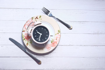 the concept of Healthy Food, alarm clock on plate 