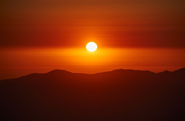 Fototapeta premium Increíble puesta de sol en un atardecer entre montañas