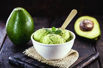 Homemade organic green avocado ice cream ready to eat, with mint leaf decorating.