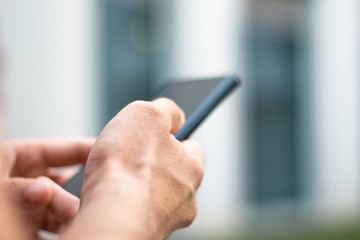 Close-up of man's hands holding a cell phone.