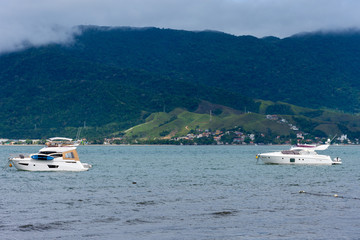 V&aacute;rio barcos na praia com uma ilha ao fundo