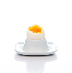 An egg boiled in a crumple for Breakfast in a stand isolated on a white background, close-up