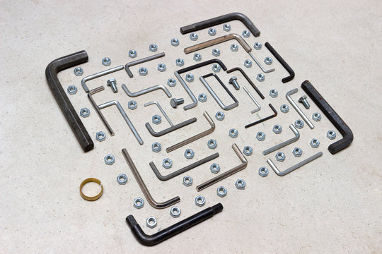 Creative Flat lay of metal and nuts on white background. Repair or improvement top view concept frame template. arranged in pac-man style. game