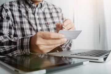 businesswoman hand using smart phone, tablet payments and holding credit card online shopping, omni channel, digital tablet docking keyboard computer at office in sun light