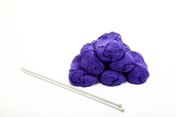 Balls of blue knitting wool and needles isolated on a white background