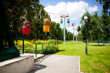 Rides in the park where people walk on a sunny day