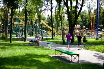 Rides in the park where people walk on a sunny day