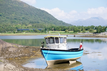 Fototapeta na wymiar Blue boat in sea water for tranquility calm peace and mindfulness in Argyll and Bute