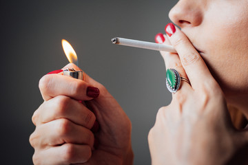 Hands of a woman lighting a cigarette