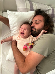 Father trying to sleep and crying baby