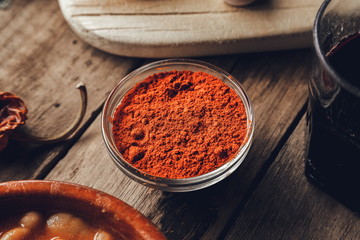 Paprika in glass bowl on rustic wooden table