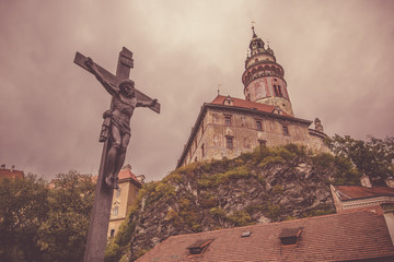 Jesus Christ on the cross with zamecka vez of Zamek Cesky Krumlov in the background