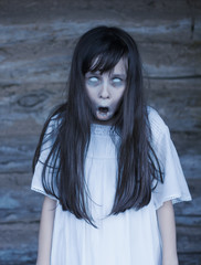 Scary ghost halloween theme. Horror devil girl with white eyes opens mouth and shouts