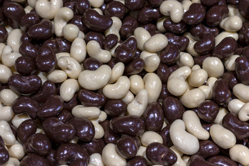 Chocolate covered peanuts. Black and white dragee. Texture background.