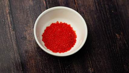 Red beads in white cup on black background