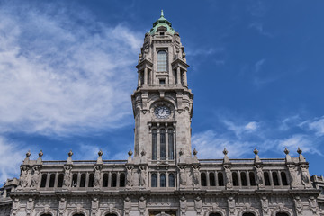 Fototapeta na wymiar View of 70m high tower with a carillon clock at City Hall building (Camara Municipal do Porto). City Hall - a Neoclassic building at Avenida dos Aliados in Porto, Portugal.