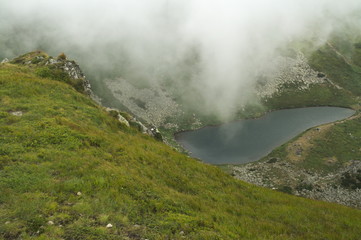Highland lake Brebenescul in the Ukrainian Carpathians mountains, above which a cloud moves