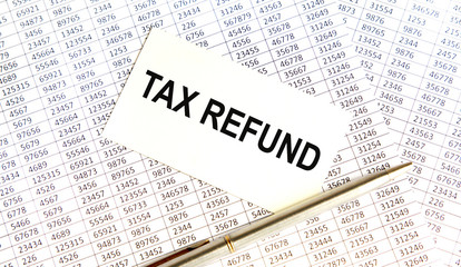 Obraz premium The inscription on the TAX REFUND card, against the background of accounting, is a pen nearby.