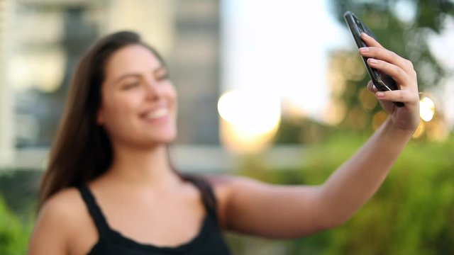 Pretty millennial girl taking selfie with cellphone
