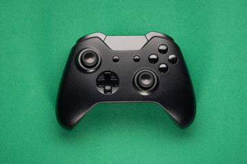 Black game Controller on green background © miglagoa