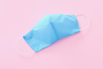 Blue medical protective mask on pink background. Healthcare and medical concept.