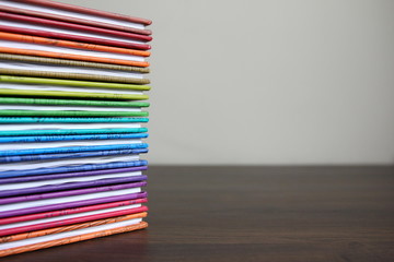 Education - books in colored covers stacked in a pile, colors of the rainbow
