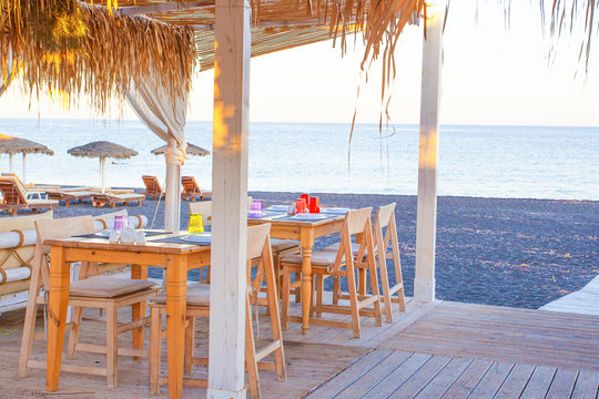 Tables near the Perissa beach in cafe, Santorini island, Greece