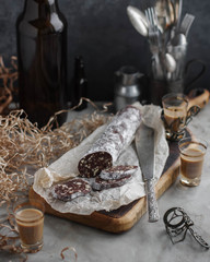 Chocolate salami on a wooden cutting board. Desserts for coffee. Homemade sweet sausage.