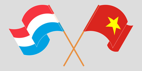 Crossed and waving flags of Luxembourg and Vietnam