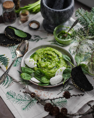 Green mashed potato with spinach and ricotta. Table setting for dinner. Vegetarian food. 