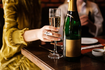 Girl holding a glass of champagne in her hand.