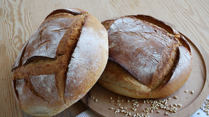 Two,rustic, whole-wheat round homemade whole bread on wooden table,close up taken