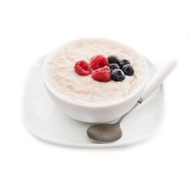 Healthy oatmeal porridge with berries for Breakfast in a white plate isolated on a white background, close-up