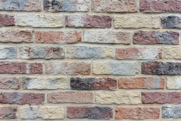 View of old shabby wall made from multicolored bricks. Abstract textured background. Copy space for your text and decorations.