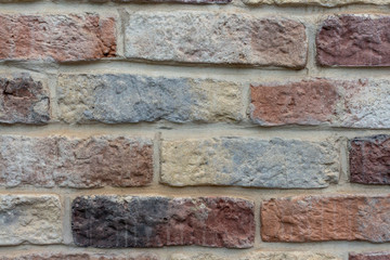 View of old shabby wall made from multicolored bricks. Abstract textured background. Copy space for your text and decorations.
