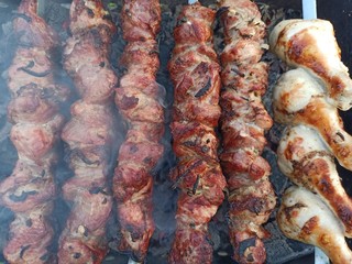 Grilled kebab cooking on metal skewer. Roasted meat cooked at barbecue. BBQ fresh beef meat chop slices. Traditional eastern dish, shish kebab. Grill on charcoal and flame, picnic, street food.