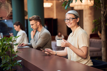Contented Asian lady enjoying coffee in beautiful cafe