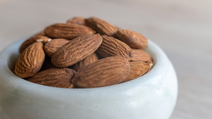Close up almonds in a white bowl.