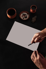 Calligraphy master work table with paper and pen