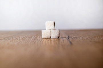three pieces of sugar on a wooden board. sugar on wood table with white background