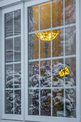 window of a warm house with freezing snow reflection