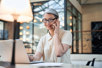 Experienced middle-aged businesswoman sitting in her office