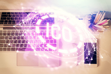 Blockchain theme hologram drawings over computer on the desktop background. Top view. Multi exposure. Concept of cryptoeconomy.