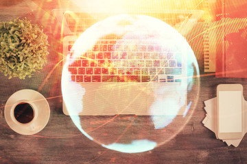 Business theme hologram drawings over computer on the desktop background. Top view. Multi exposure. Concept of international connections.