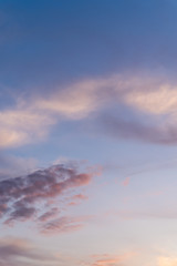 Beautiful bright sunset. Soft colors of clouds and sky. Quiet background. Blue and white colors. Vertical photo