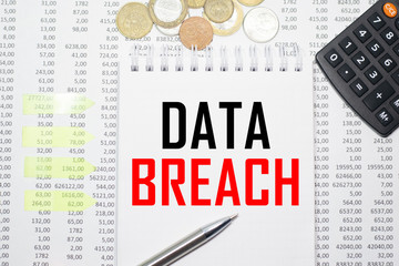 DATA BREACH on the block on the background of financial reporting, coins, calculator, pens and yellow stickers. Business concept