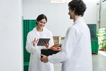 Fototapeta premium Woman with a tablet standing next to a worker