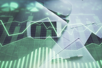Multi exposure of forex graph hologram over desktop with phone. Top view. Mobile trade platform concept.