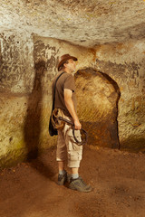 Adventurer in ancient cave on trace of mysterious emerald tablet finding famous artifact